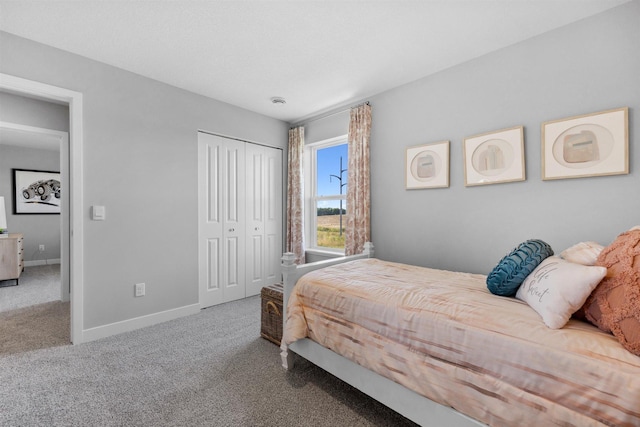 carpeted bedroom with a closet and baseboards