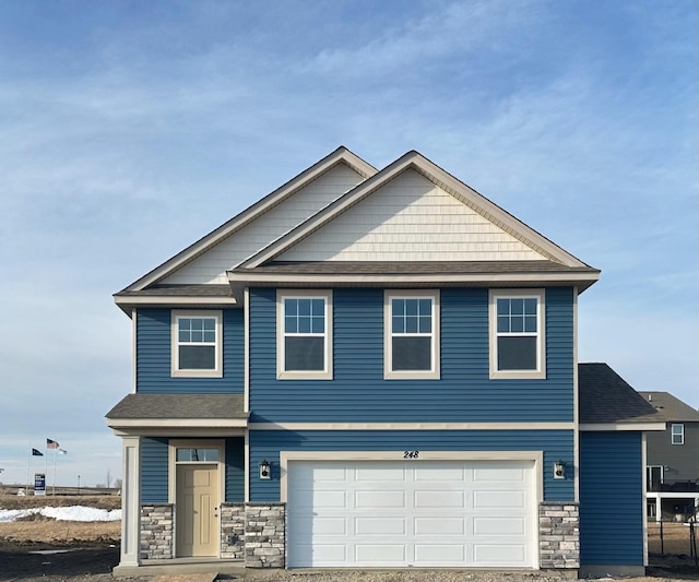 craftsman inspired home featuring an attached garage and stone siding