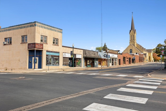 view of road with traffic signs, curbs, sidewalks, and street lighting