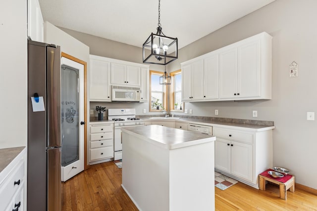 2316 Coldwater Xing, Mayer, MN 55360 - kitchen with white appliances, a sink, light wood finished floors, white cabinetry, and a kitchen island