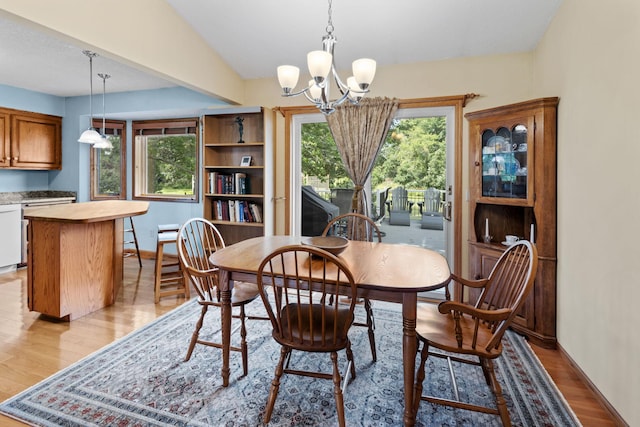 dining room featuring baseboards, an inviting chandelier, and light wood finished floors