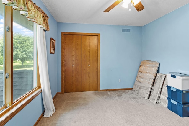 interior space featuring a ceiling fan, baseboards, visible vents, and a closet