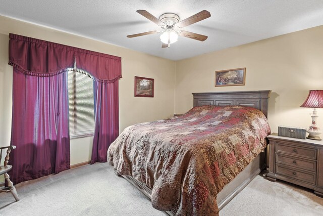 carpeted bedroom featuring baseboards, a textured ceiling, and ceiling fan