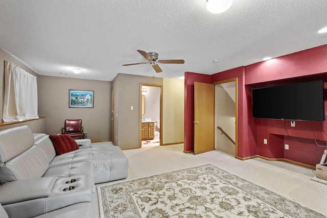 carpeted living area with ceiling fan, a textured ceiling, and baseboards