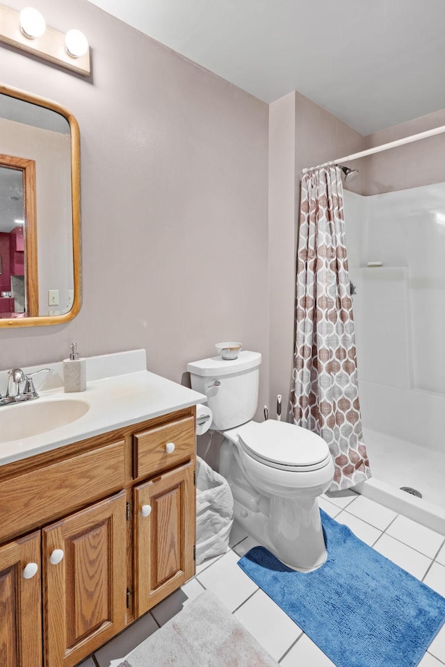 bathroom with tile patterned floors, toilet, a stall shower, and vanity