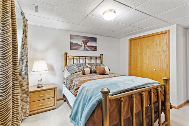 bedroom with a drop ceiling, visible vents, light carpet, and baseboards