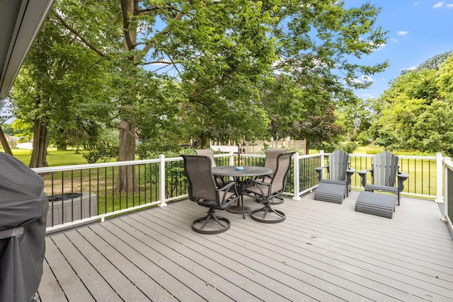 deck with outdoor dining space and a yard