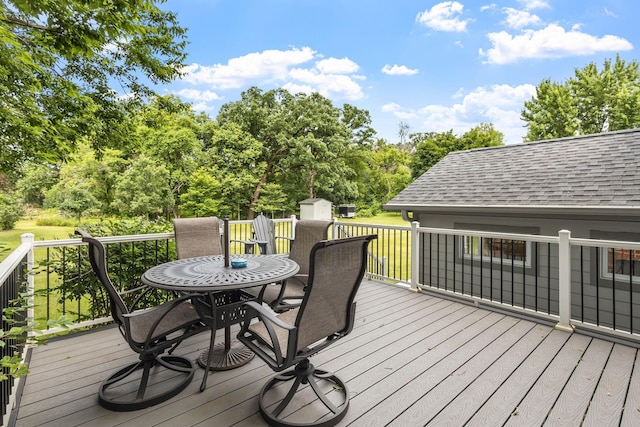 wooden deck with a storage shed, outdoor dining space, and an outdoor structure