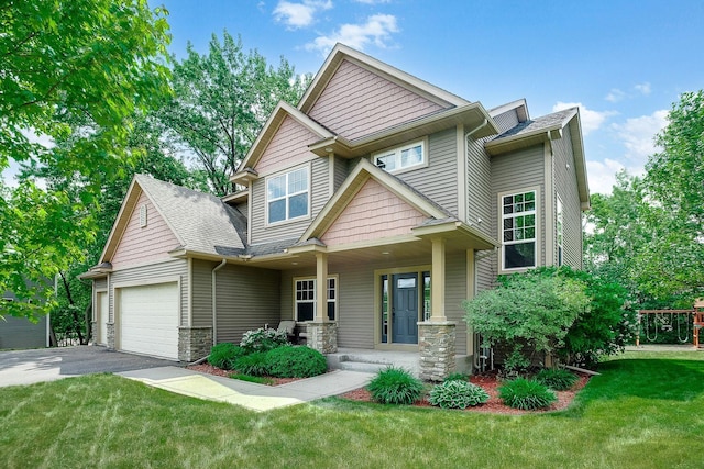 craftsman-style home featuring roof with shingles, a porch, an attached garage, a front lawn, and aphalt driveway