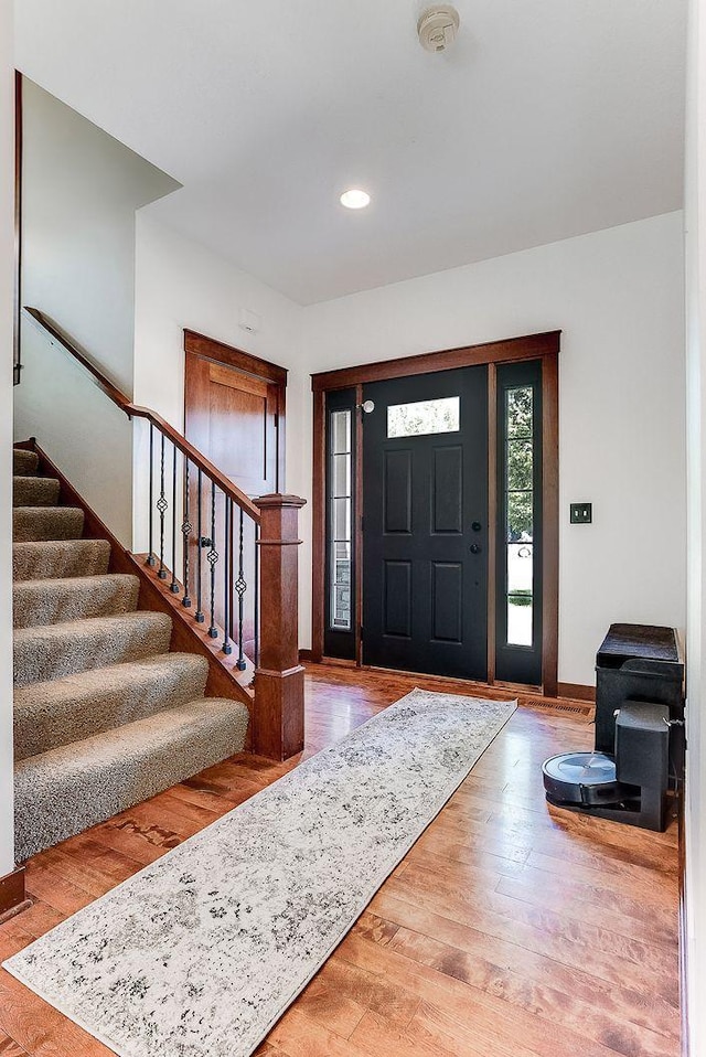 foyer with stairway, recessed lighting, baseboards, and wood finished floors