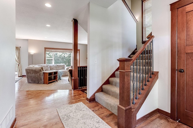 stairway featuring recessed lighting, visible vents, baseboards, and wood finished floors