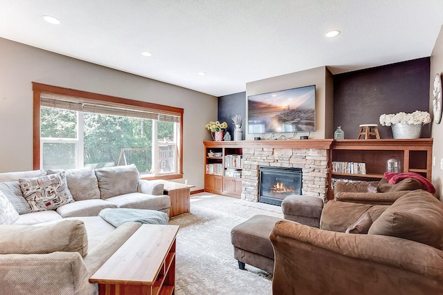 living area with a stone fireplace, recessed lighting, and light colored carpet