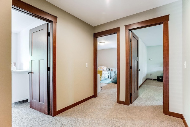 corridor with light carpet and baseboards