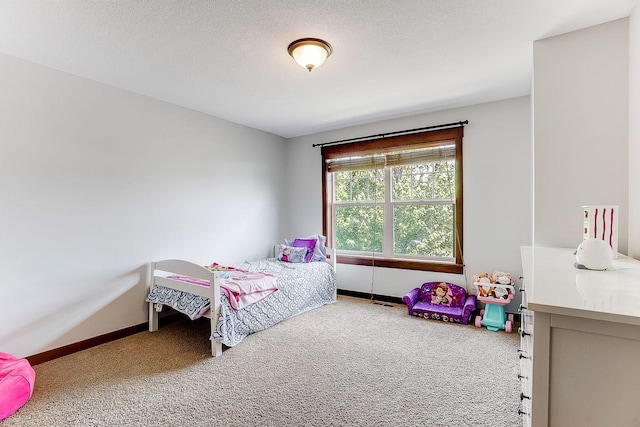 carpeted bedroom with baseboards and a textured ceiling