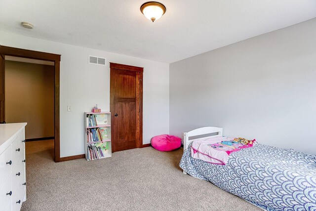 carpeted bedroom featuring visible vents and baseboards