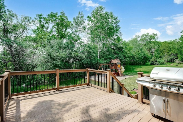 wooden terrace with a grill, a playground, and a yard