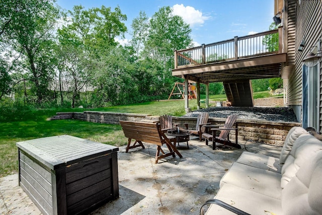 view of patio with a fire pit, a playground, and a deck