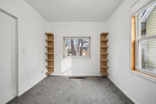 carpeted empty room featuring visible vents and baseboards