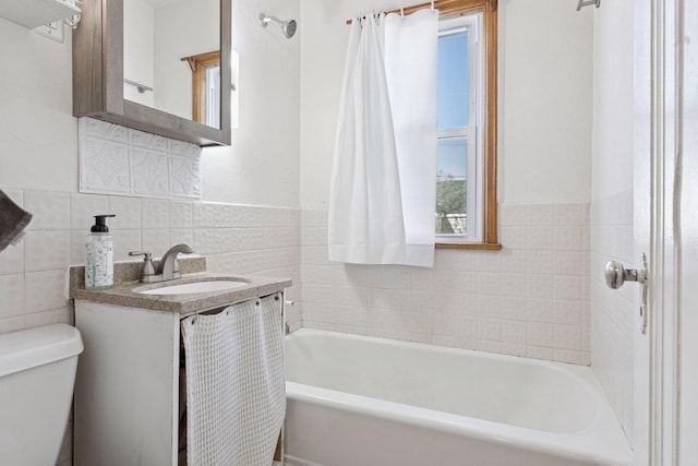 bathroom with toilet, a washtub, tile walls, and vanity