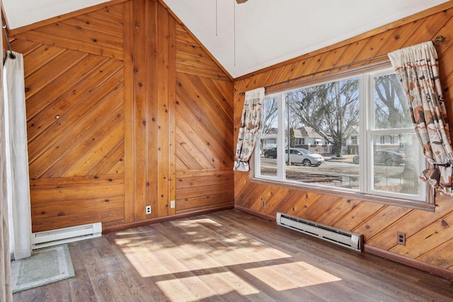 unfurnished dining area with vaulted ceiling, baseboard heating, wood walls, and wood finished floors