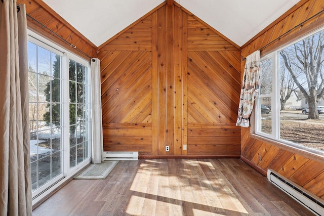 unfurnished sunroom with plenty of natural light, a baseboard heating unit, and lofted ceiling