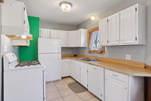 kitchen with a sink, white appliances, and white cabinets