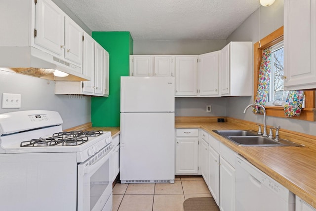 kitchen featuring white appliances, white cabinets, under cabinet range hood, and a sink