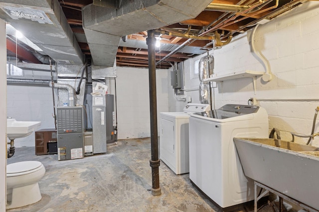 unfinished below grade area with a sink, heating unit, and washing machine and clothes dryer