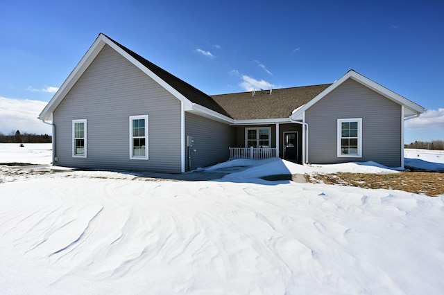 snow covered property with covered porch