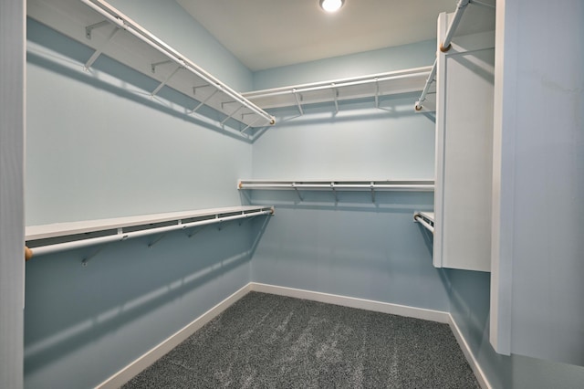 spacious closet featuring dark carpet