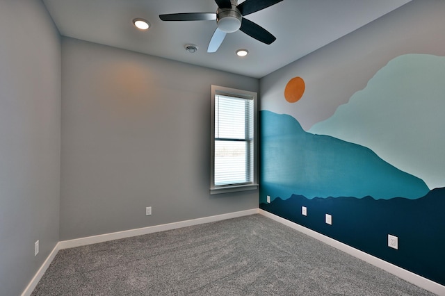 carpeted spare room with baseboards and ceiling fan