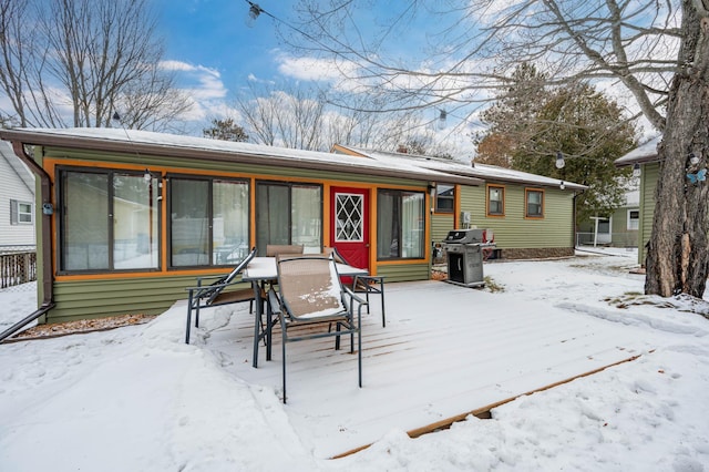 snow covered house with outdoor dining area