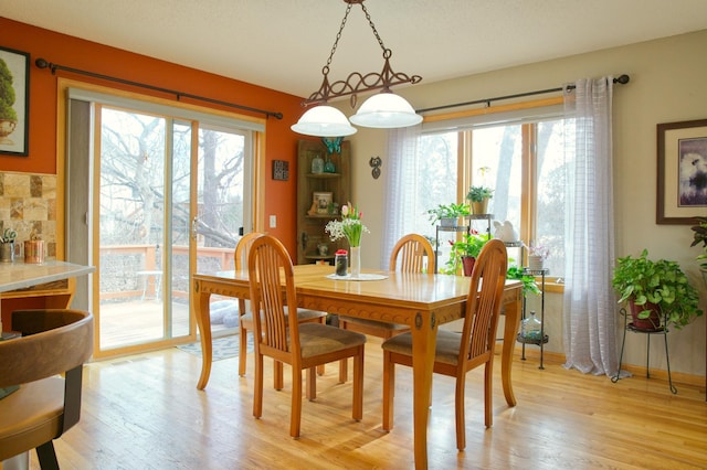 dining space featuring light wood finished floors and baseboards