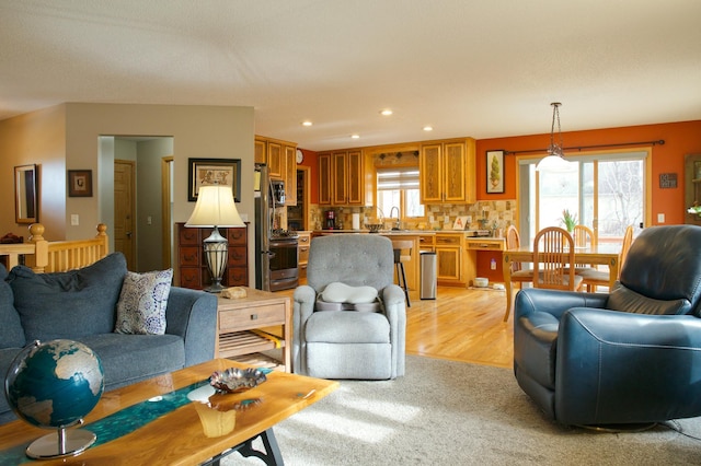 living room with recessed lighting, a healthy amount of sunlight, and light colored carpet