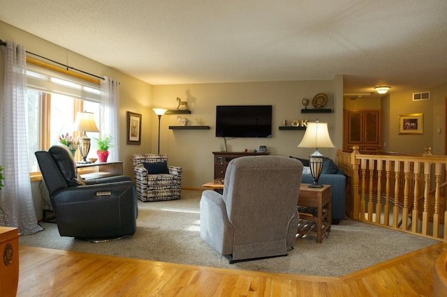 living area with visible vents and wood finished floors