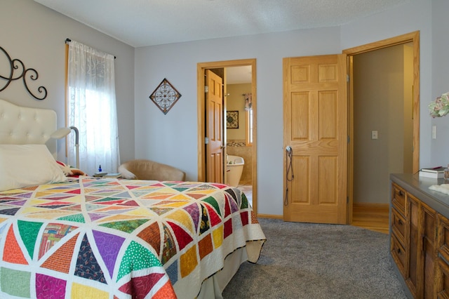 carpeted bedroom with a textured ceiling and ensuite bathroom