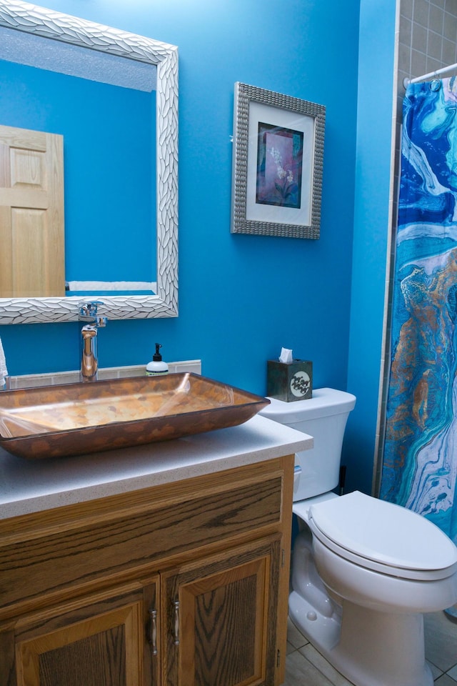 bathroom with a shower with shower curtain, toilet, vanity, and tile patterned floors