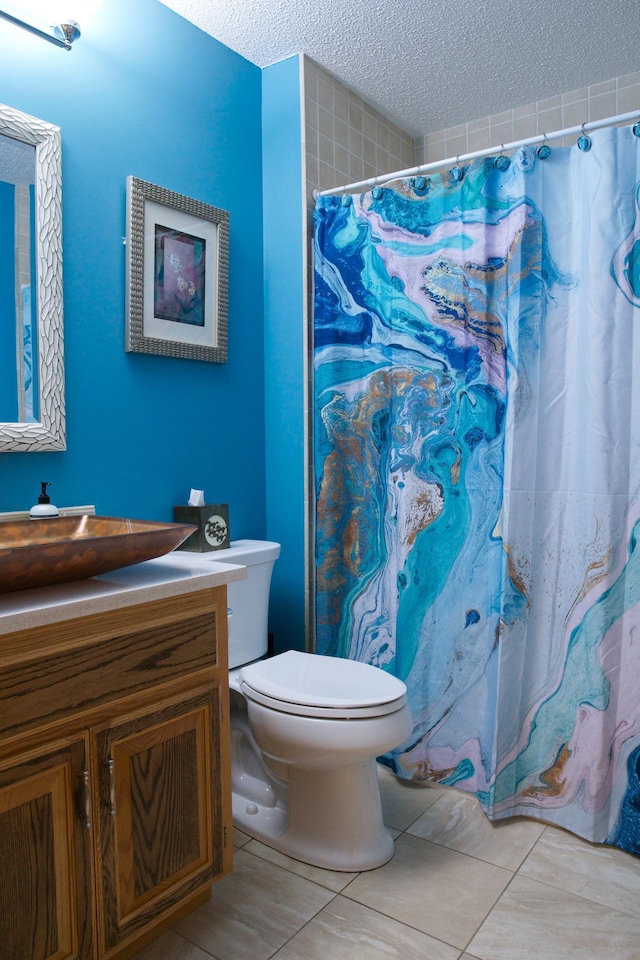 bathroom featuring tile patterned floors, toilet, curtained shower, a textured ceiling, and vanity