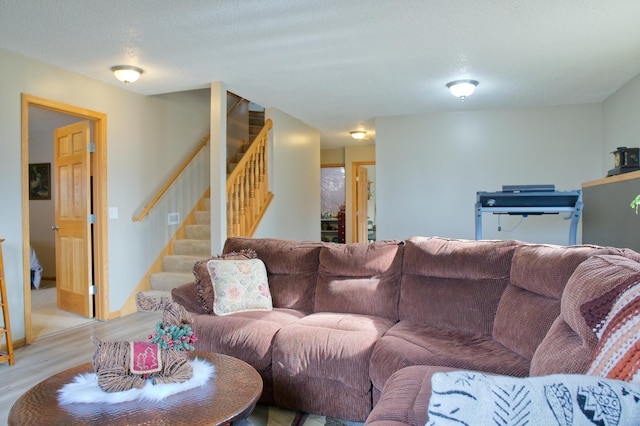 living area featuring light wood-type flooring and stairs