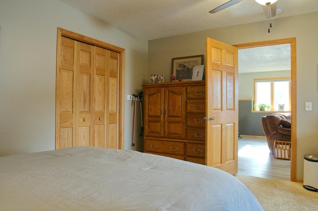 bedroom with a ceiling fan, baseboards, a textured ceiling, and carpet flooring