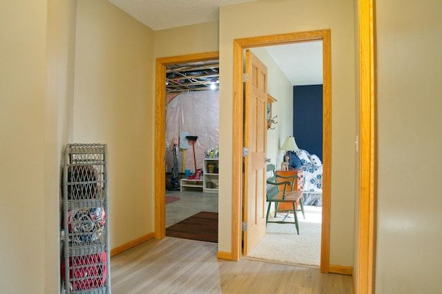 hallway featuring baseboards and wood finished floors