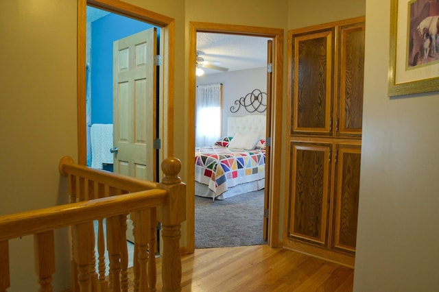 hallway featuring an upstairs landing and light wood finished floors