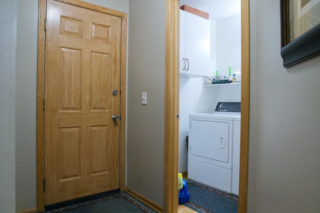 washroom featuring baseboards, cabinet space, and washer / dryer