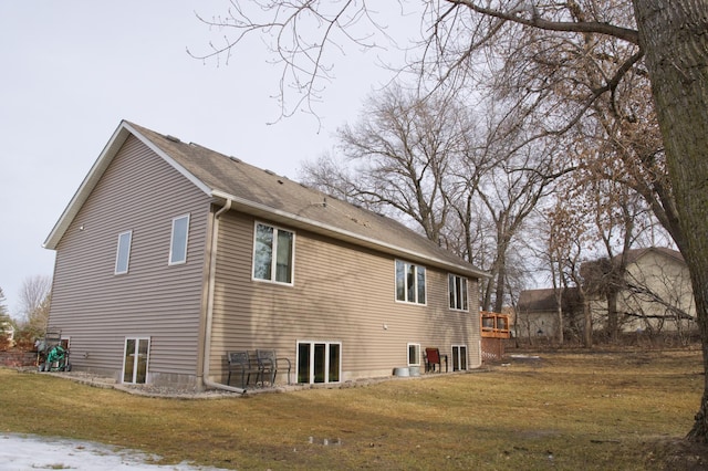 view of home's exterior with a lawn and a shingled roof