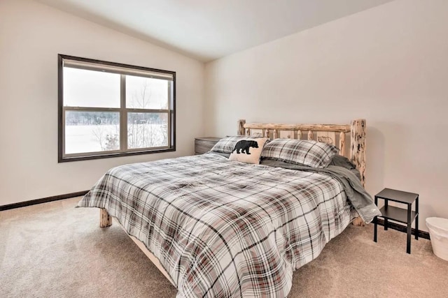 carpeted bedroom featuring baseboards and lofted ceiling