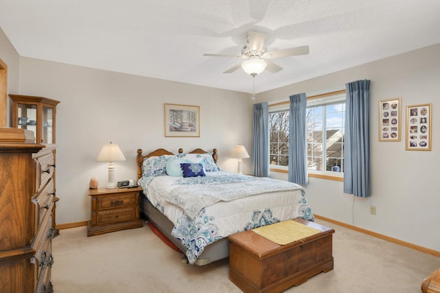 bedroom with light carpet, a ceiling fan, and baseboards