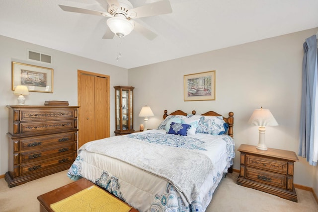 carpeted bedroom with visible vents, baseboards, a closet, and a ceiling fan