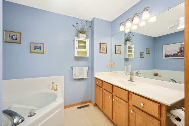 bathroom featuring vanity, a garden tub, baseboards, and visible vents