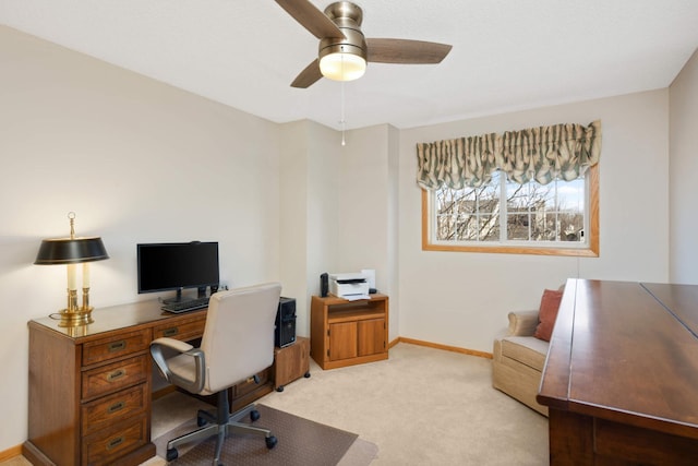 office space with a ceiling fan, light colored carpet, and baseboards