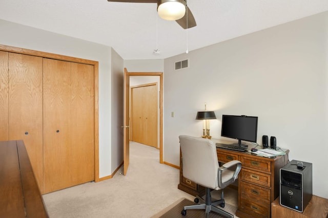 office area with visible vents, light colored carpet, baseboards, and a ceiling fan